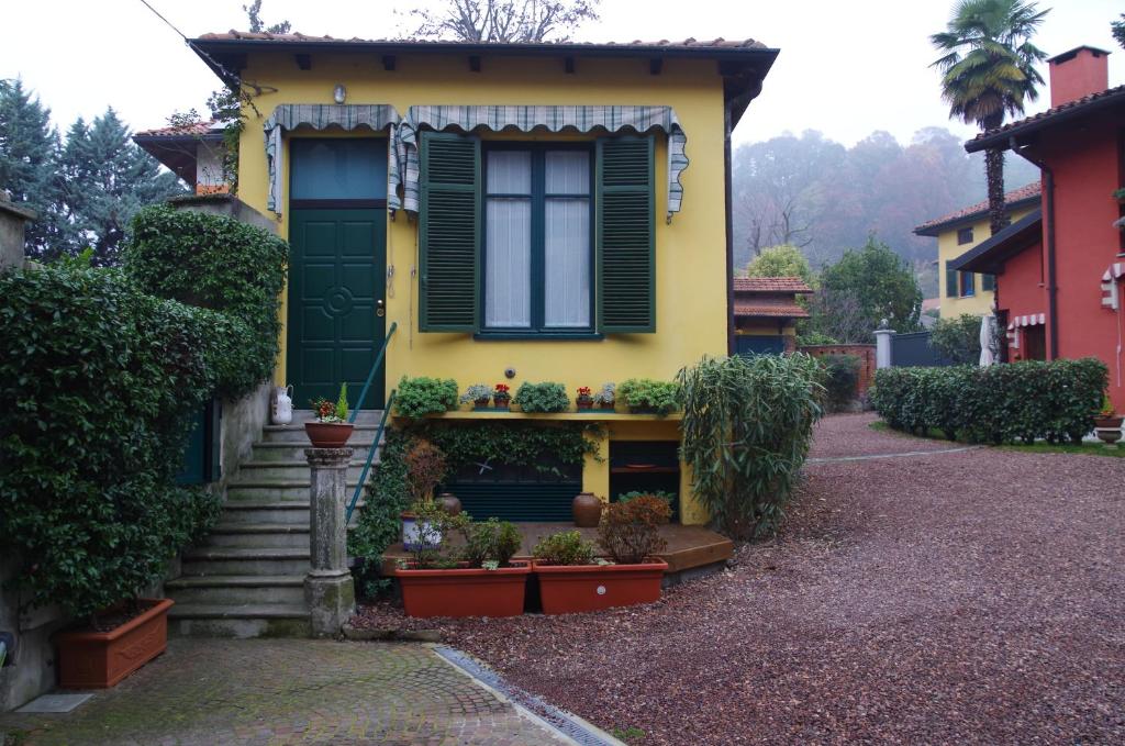 een geel huis met een raam en een aantal planten bij LA CASETTA in Biella