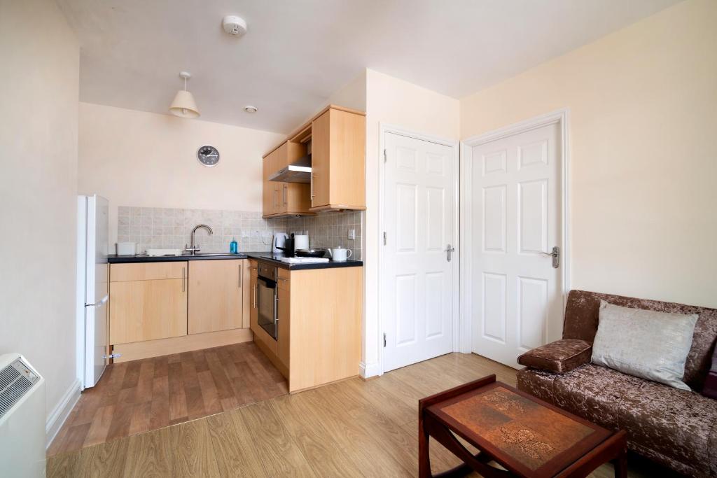 a living room with a couch and a kitchen at Becket apartment in Yeovil