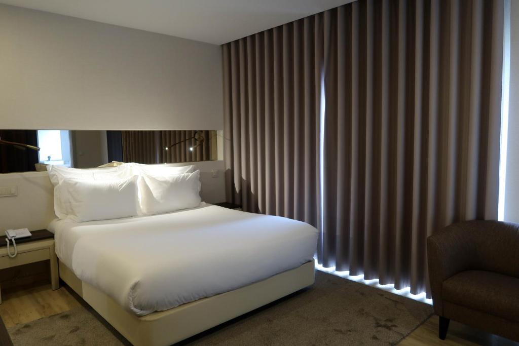 Кровать или кровати в номере Hotel Cristal Setúbal