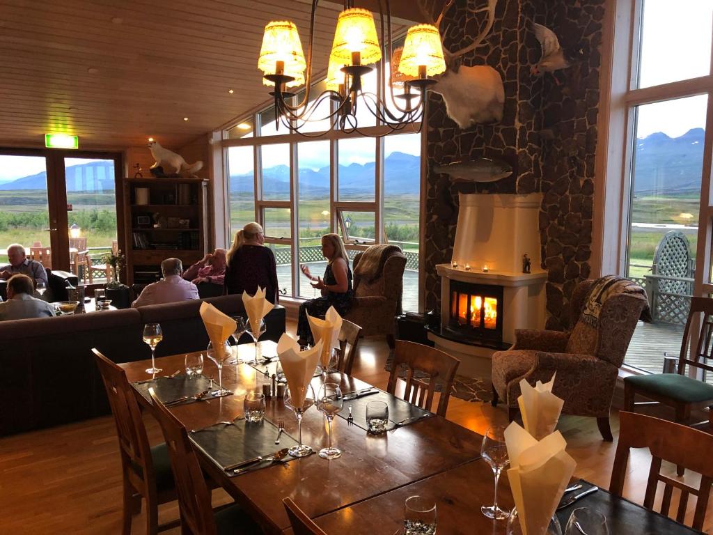 a dining room with a table and a fireplace at Eyjar Fishing Lodge in Breiðdalsvík