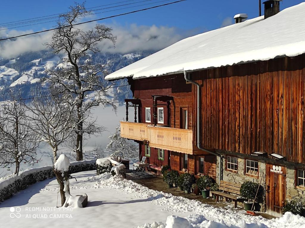 um grande edifício de madeira com neve em Apart Ponholz em Hart im Zillertal