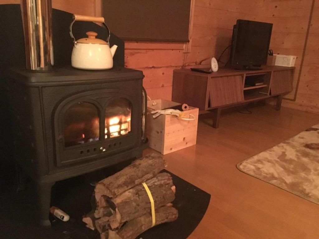 a fireplace in a living room with a stove at Trust Maison Shirada - Vacation STAY 18437v in Higashiizu