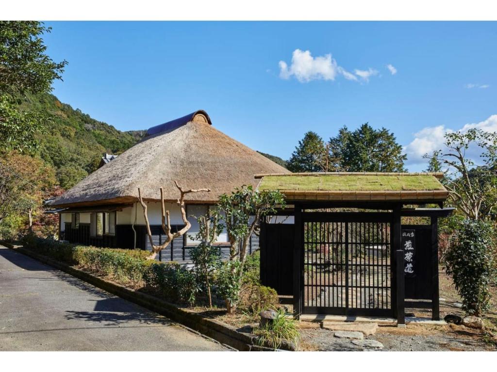 un petit bâtiment avec un toit de chaume et un portail dans l'établissement Kayabuki Kominka Syuzenji - Vacation STAY 18448v, à Izu