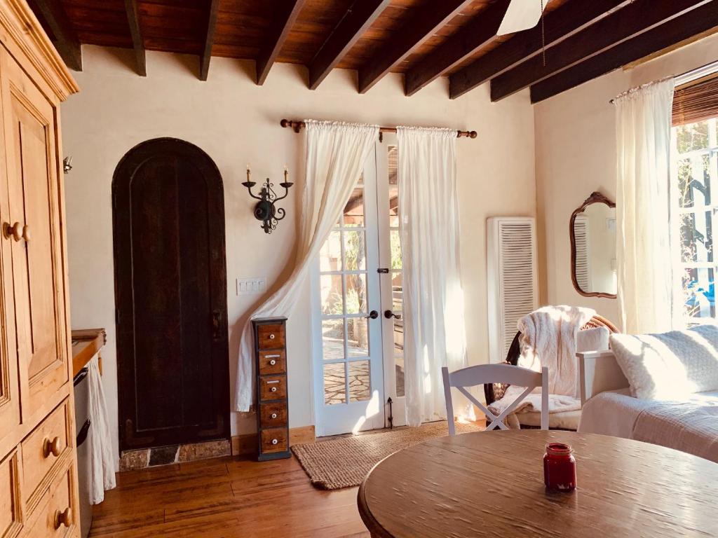 a living room with a table and a bed and a window at Under the Tuscan Sun Cottage in West Los Angeles in Los Angeles