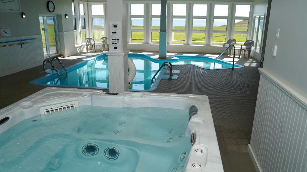 a jacuzzi tub in a room with two swimming pools at Château Madelinot in Fatima
