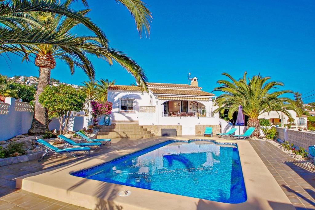 a house with a swimming pool and palm trees at Paula-3 - holiday home with private swimming pool in Moraira in Moraira