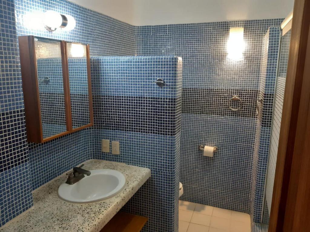 uma casa de banho em azulejos azuis com um lavatório e um chuveiro em Casa Maya private villa on the beach em Puerto Escondido