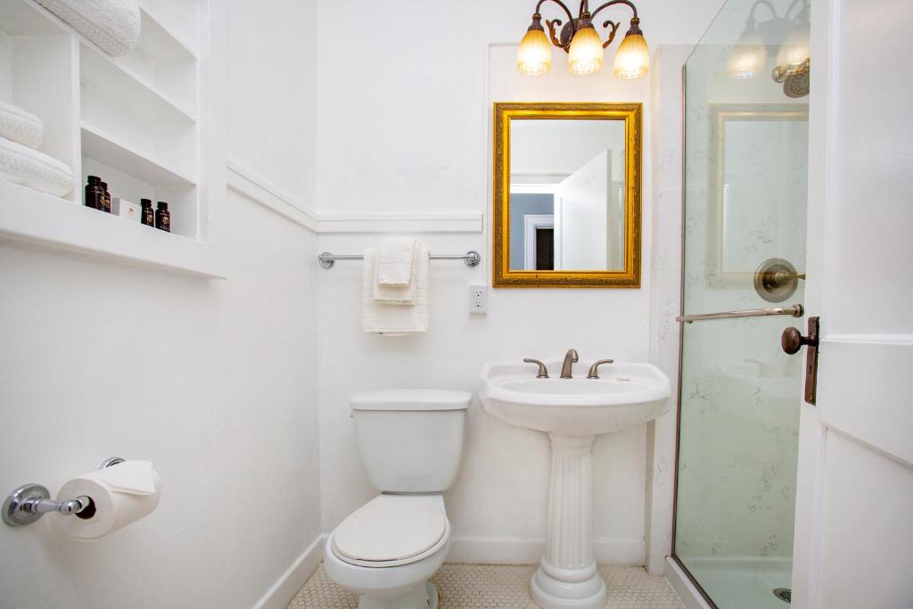 a bathroom with a toilet and a sink and a mirror at MarQueen Hotel in Seattle