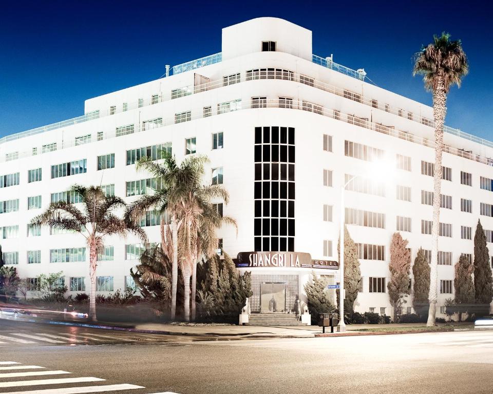 a white building with palm trees in front of it at Hotel Shangri-La in Los Angeles