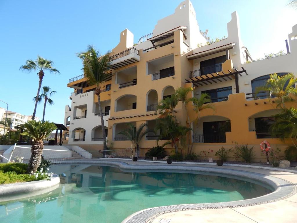 a building with a swimming pool in front of a building at Studio At Marina Los Cabos in Cabo San Lucas