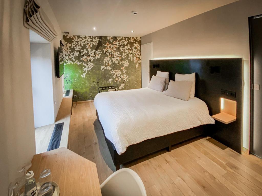 een slaapkamer met een groot bed in een kamer bij LA GLORIETTE in Marche-en-Famenne
