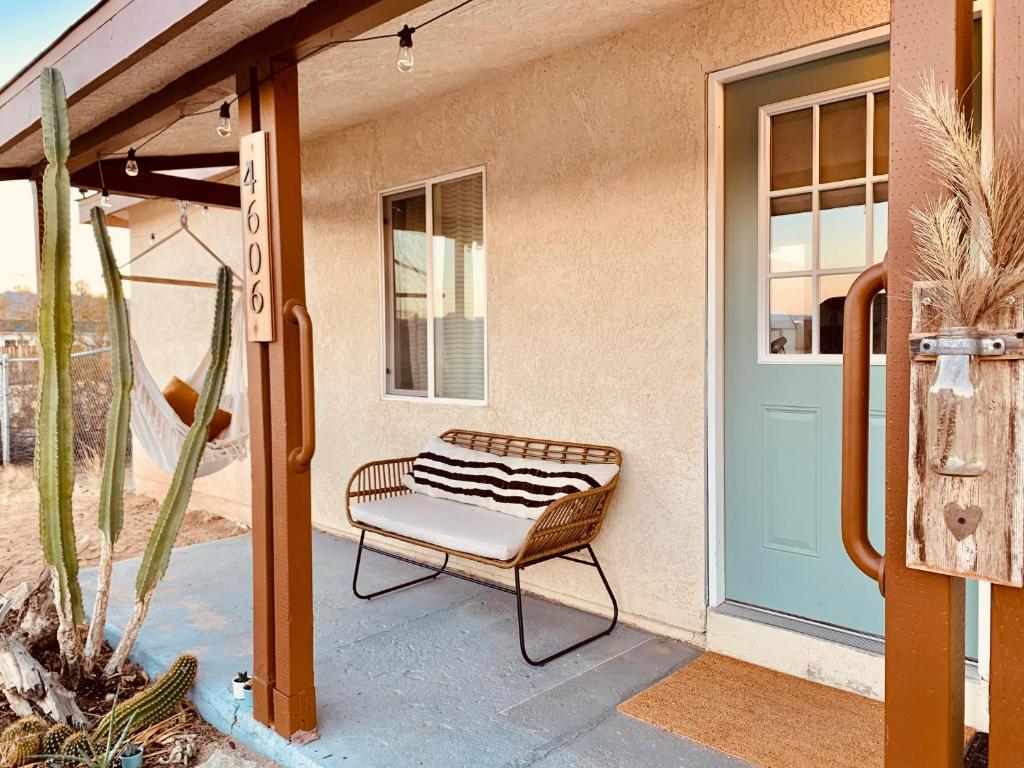 a chair sitting on a porch next to a door at Casa Agave: Comfy Joshua Tree Cottage With Free Breakfast Bar in Joshua Tree