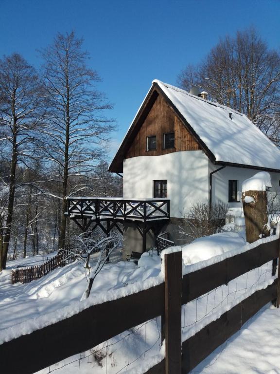 a house in the snow with a fence at Trzy Strumyki in Kąty Bystrzyckie
