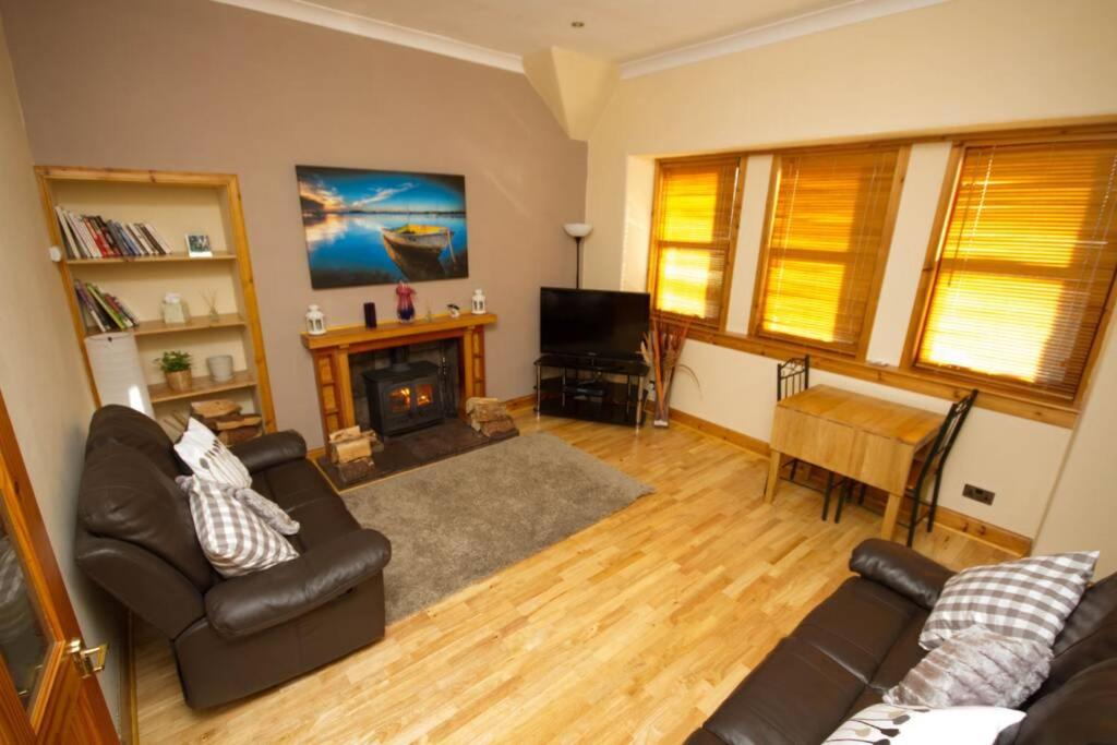 a living room with a couch and a fireplace at Mallaig Self Catering Apartment in Mallaig