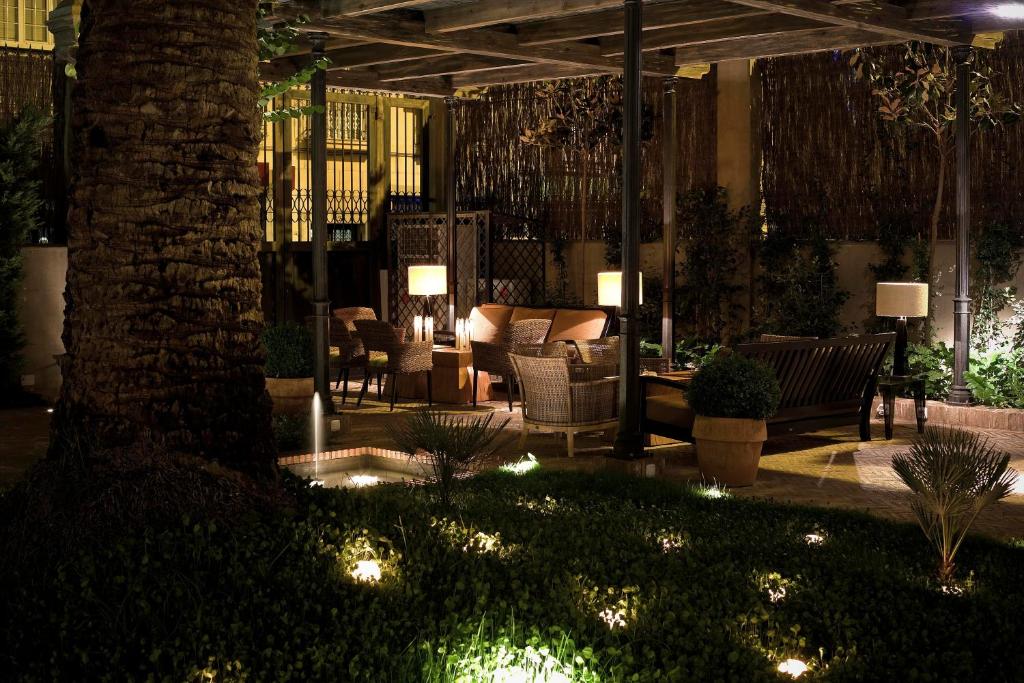 a patio with chairs and a table with lights at Villa Oniria in Granada