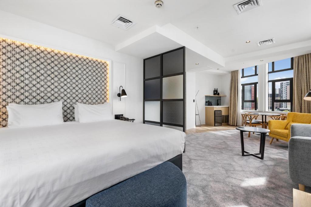 a bedroom with a bed and a living room at Airedale Boutique Suites in Auckland