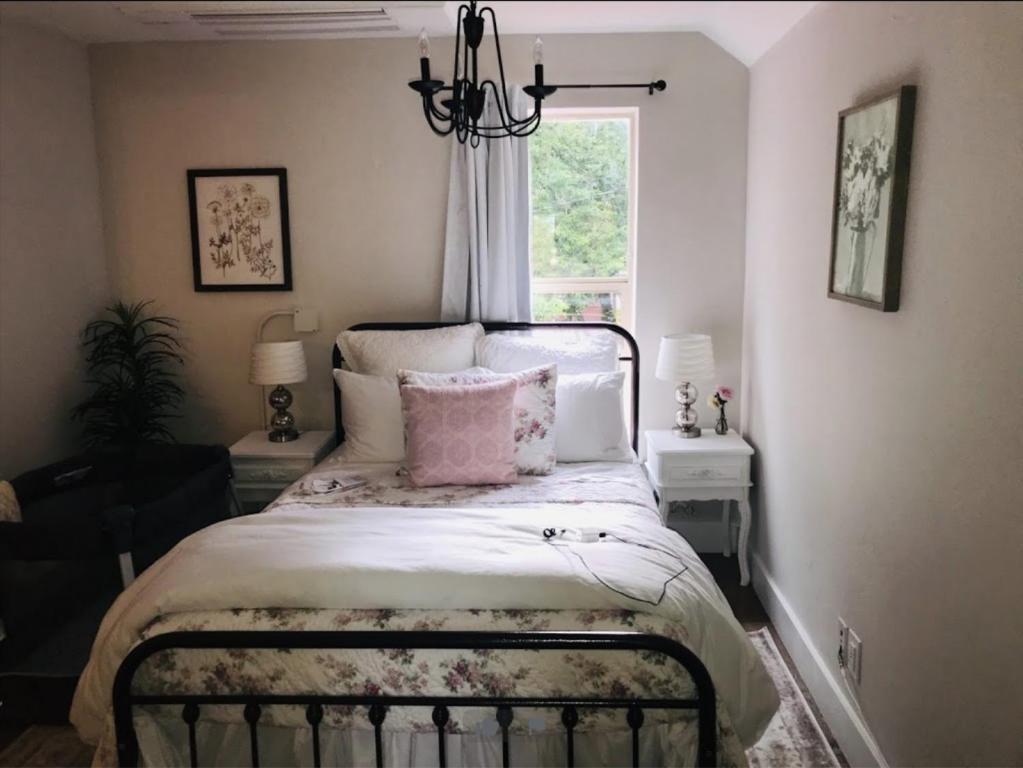 a bedroom with a bed with a chandelier and a window at The Farmhouse Inn & Kitchen, 2 blocks from Downtown Whitefish, Montana in Whitefish