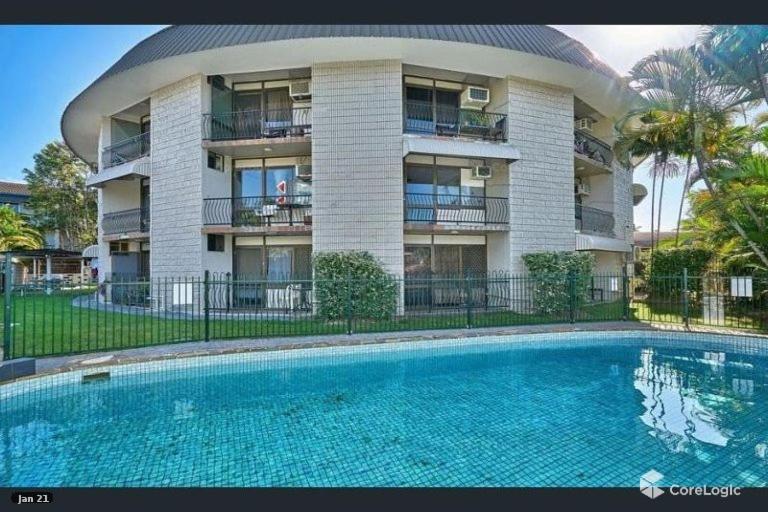 a building with a swimming pool in front of a building at Residential two bedroom, self-contained, renovated apartment, Sheridan St, self check-in in Cairns