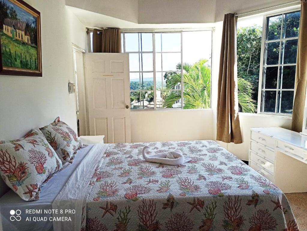 a bedroom with a bed and a large window at Columbus Heights Apt 26 F in Ocho Rios