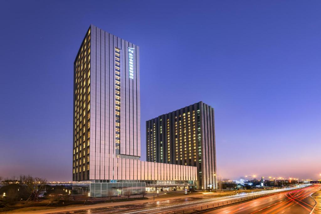 un edificio alto frente a una autopista por la noche en Novotel Changsha International Exhibition Center, en Changsha