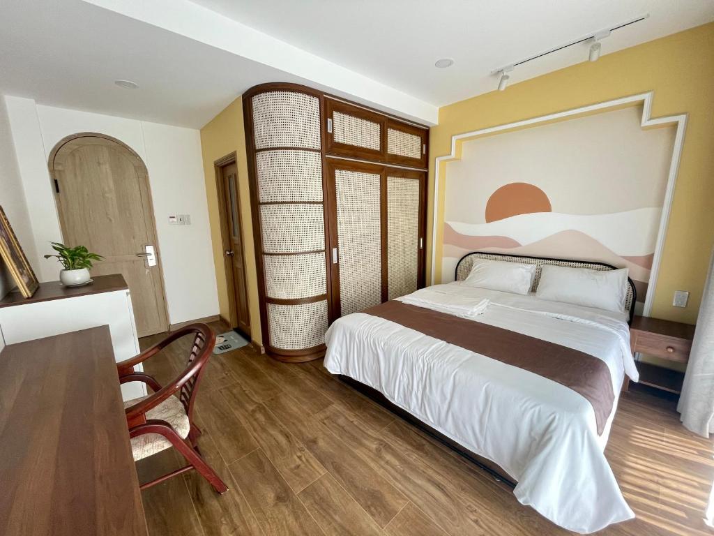 una camera con un grande letto e un tavolo di Emmie Nha Trang Hotel a Nha Trang