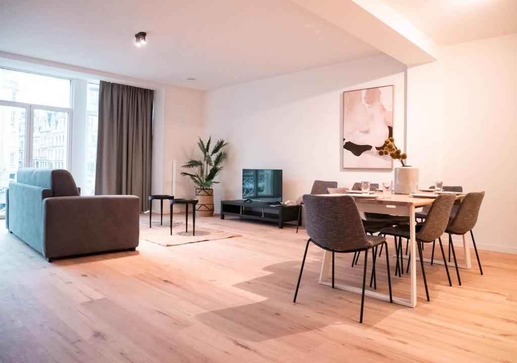 een woonkamer met een eettafel en stoelen bij Smartflats - Antwerp View in Antwerpen