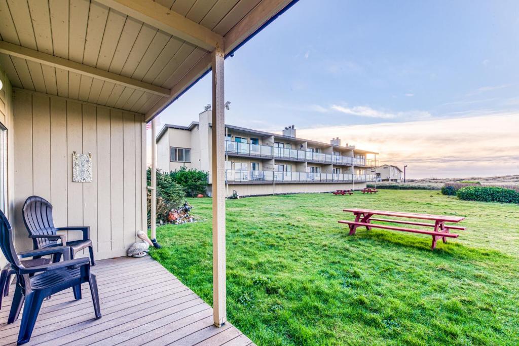 a porch with a bench and a building in the background at Hi-Tide Resort in Moclips