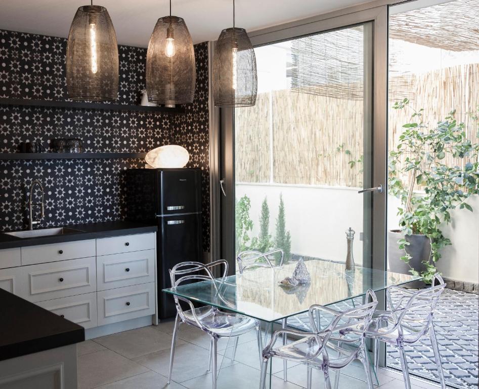 a kitchen with a glass table and chairs at Etis garden seafront in Haifa