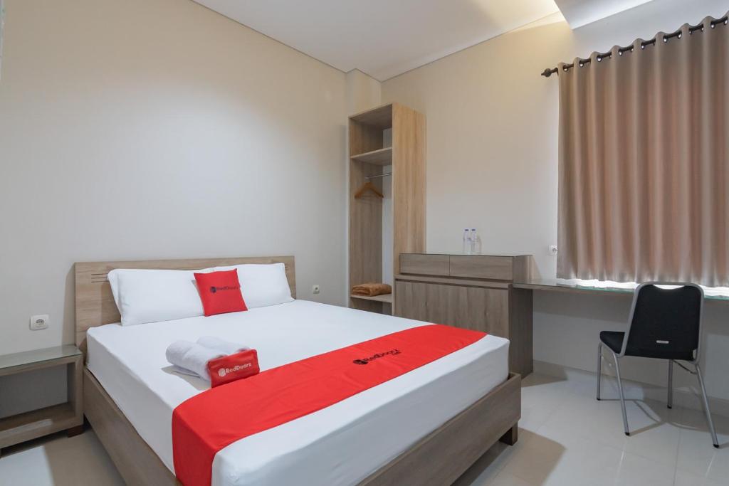 1 dormitorio con 1 cama con escritorio y silla en RedDoorz Plus @ Cirebon City Center en Cirebon