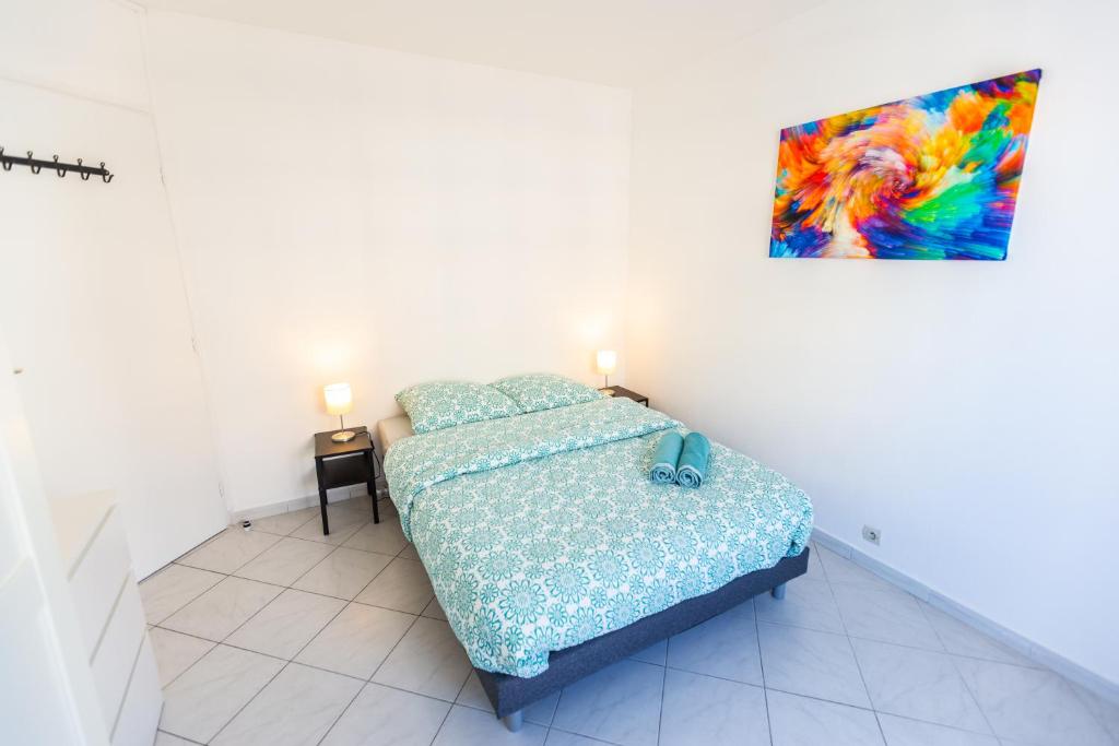 a bedroom with a bed and a painting on the wall at Superbe 100m2 - 2 Balcons - Proche Gare - Climatisé in Marseille