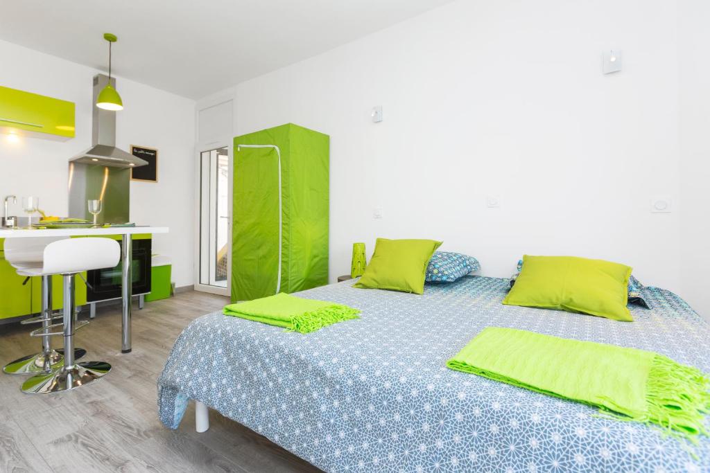 アヴィニョンにあるStudio Malpeignéのベッドルーム1室(緑の枕が付くベッド1台付)、キッチンが備わります。