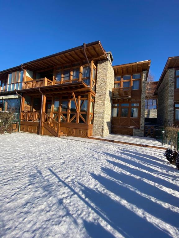 a house with a snow covered driveway in front of it at Katarino Spa Chalet in Razlog