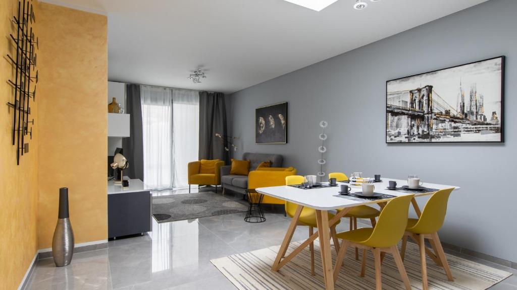 una sala da pranzo con tavolo bianco e sedie gialle di Promenade Apartments by Quokka 360 - modern apartments of design a Paradiso