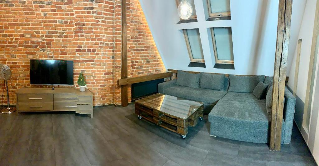 Televízia a/alebo spoločenská miestnosť v ubytovaní Apartamenty Młyńska 4