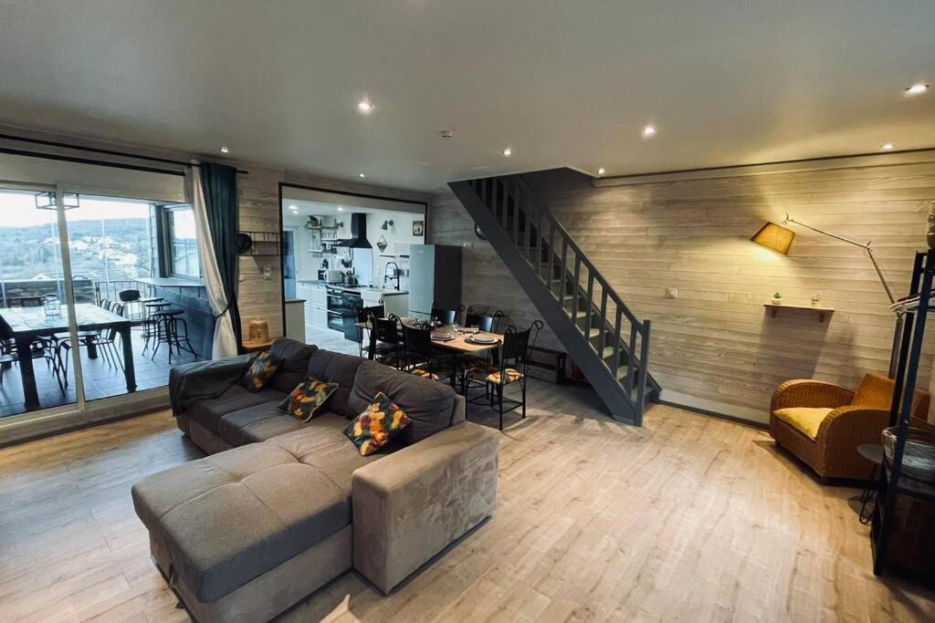 uma grande sala de estar com um sofá e uma escada em La BOUGERIE de Chaligny à 15 min de Nancy em Chaligny