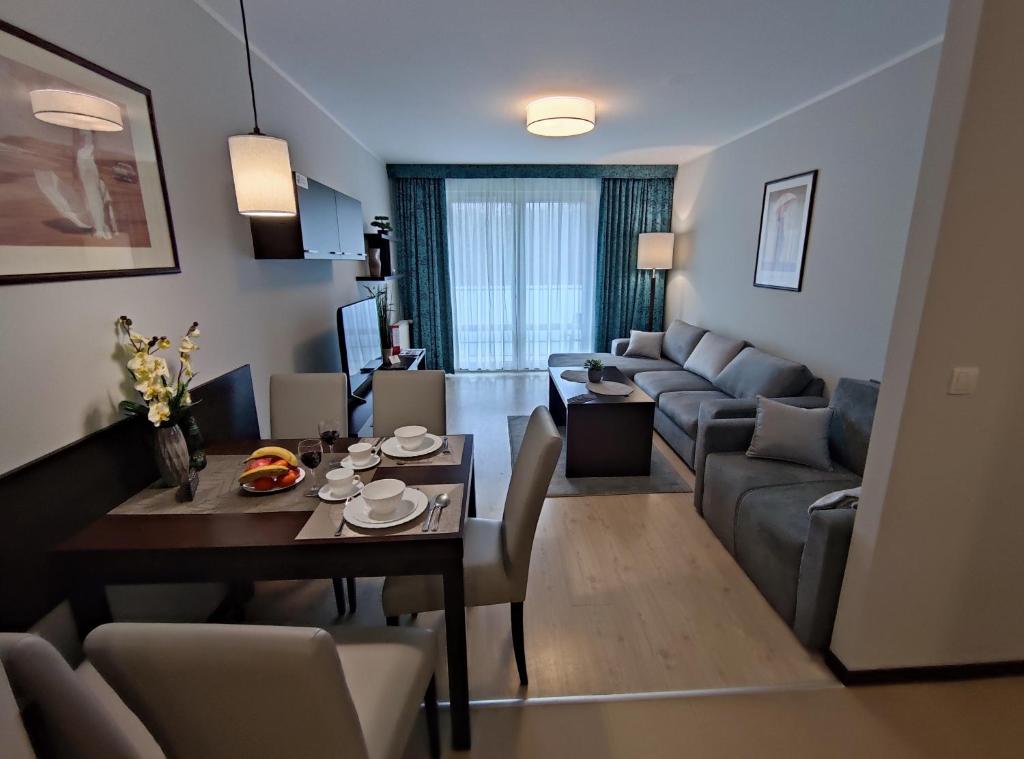 a living room with a table and a couch at Apartament przy hotelu Aquarius in Kołobrzeg