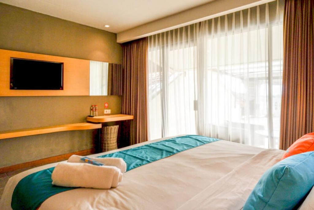 Postel nebo postele na pokoji v ubytování Sans Hotel Ekkon Yogyakarta by Reddoorz