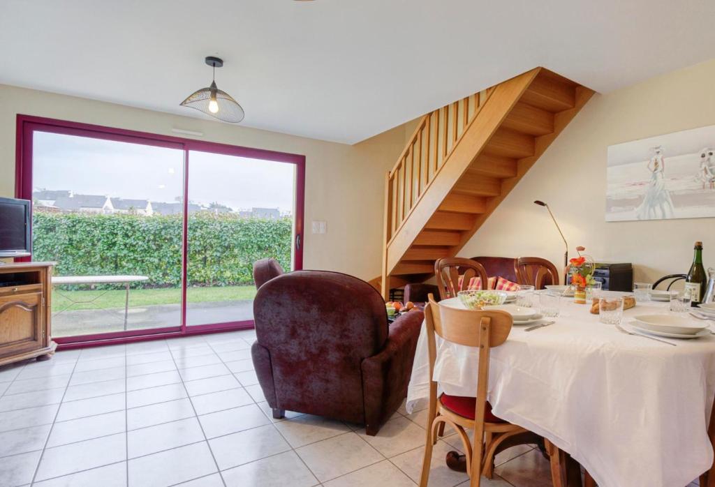 a dining room with a table and a large window at Maison Charles - plage à 800 m in Pléneuf-Val-André