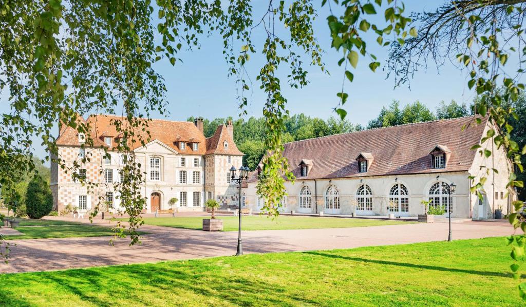 - une vue sur l'extérieur d'un grand bâtiment avec une cour dans l'établissement Château d'Hermival, à Hermival-les-Vaux