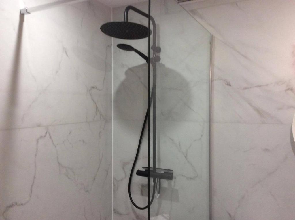 een douche in een badkamer met witte marmeren muren bij Ostend Central Residence in Oostende