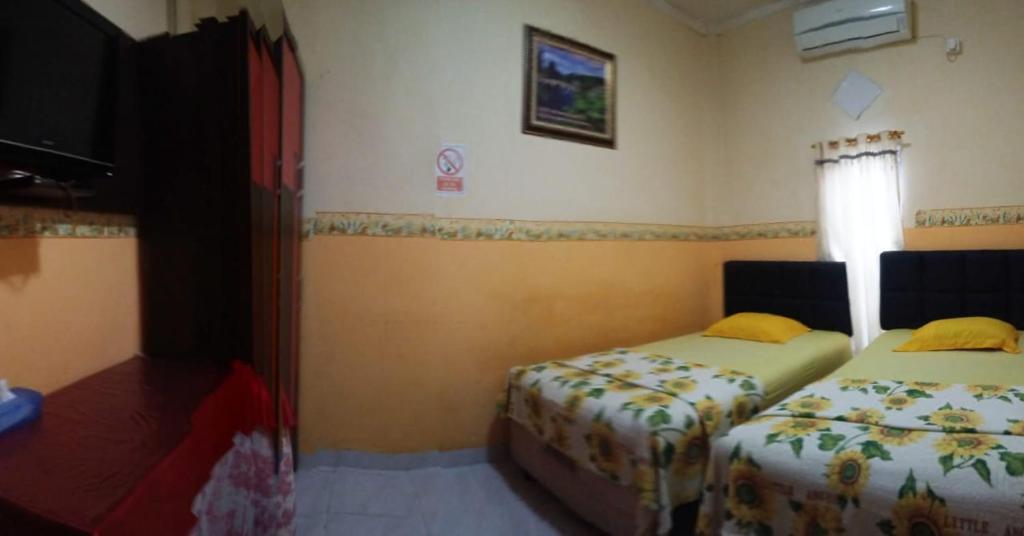 Postel nebo postele na pokoji v ubytování HOTEL NAYORA PRABUMULIH