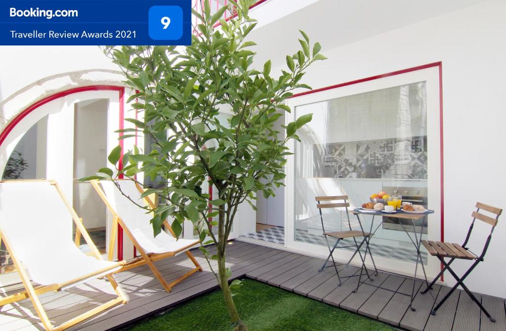 a patio with chairs and a tree on a deck at HM - The Garden in Porto