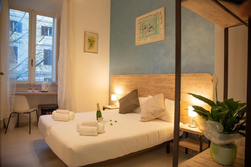 a bedroom with a bed and a table with a bottle of champagne at Romerooms in Rome