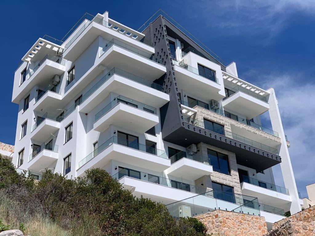 a white apartment building on top of a hill at Lux Apartments Pinctada in Dobra Voda