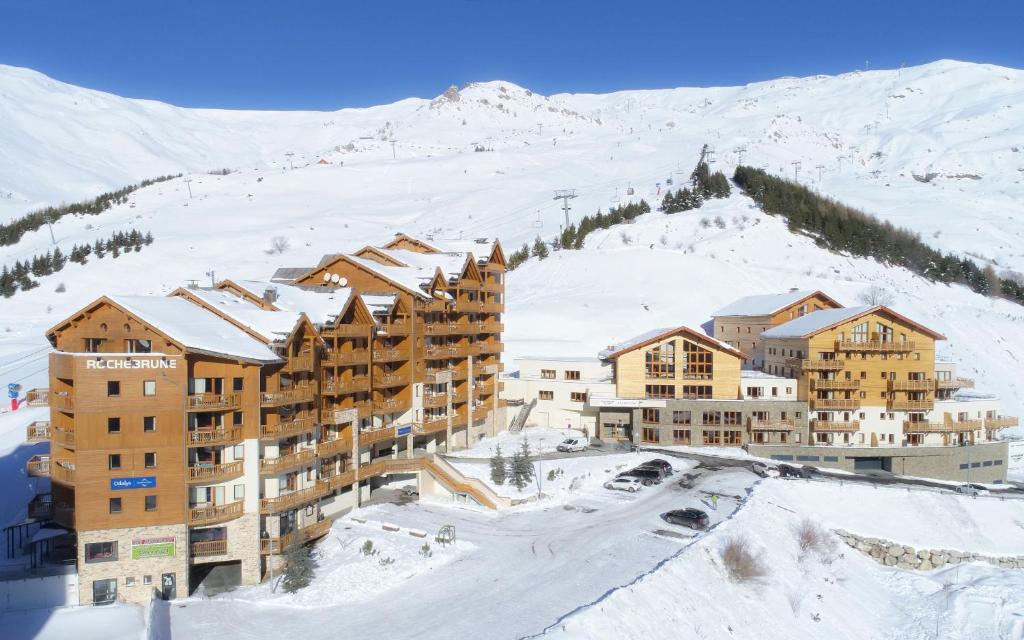 un groupe de bâtiments dans la neige sur une montagne dans l'établissement Résidence Prestige Odalys Rochebrune Les Cimes, à Orcières