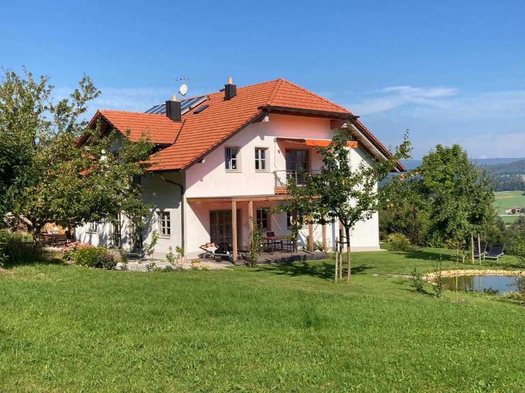 une maison avec un toit rouge sur une pelouse verte dans l'établissement LICHTECK - Helle Ferien, à Breitenberg