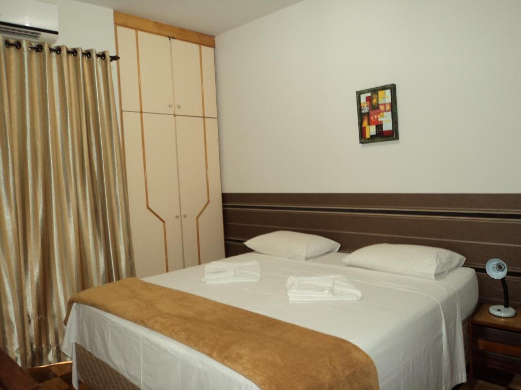 1 dormitorio con 1 cama con 2 almohadas blancas en Iguassu Central Flats, en Foz do Iguaçu