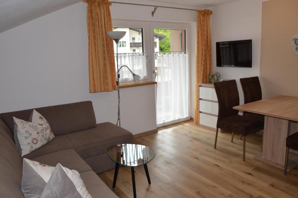 een woonkamer met een bank en een tafel bij Haus Regenbogen in Pertisau