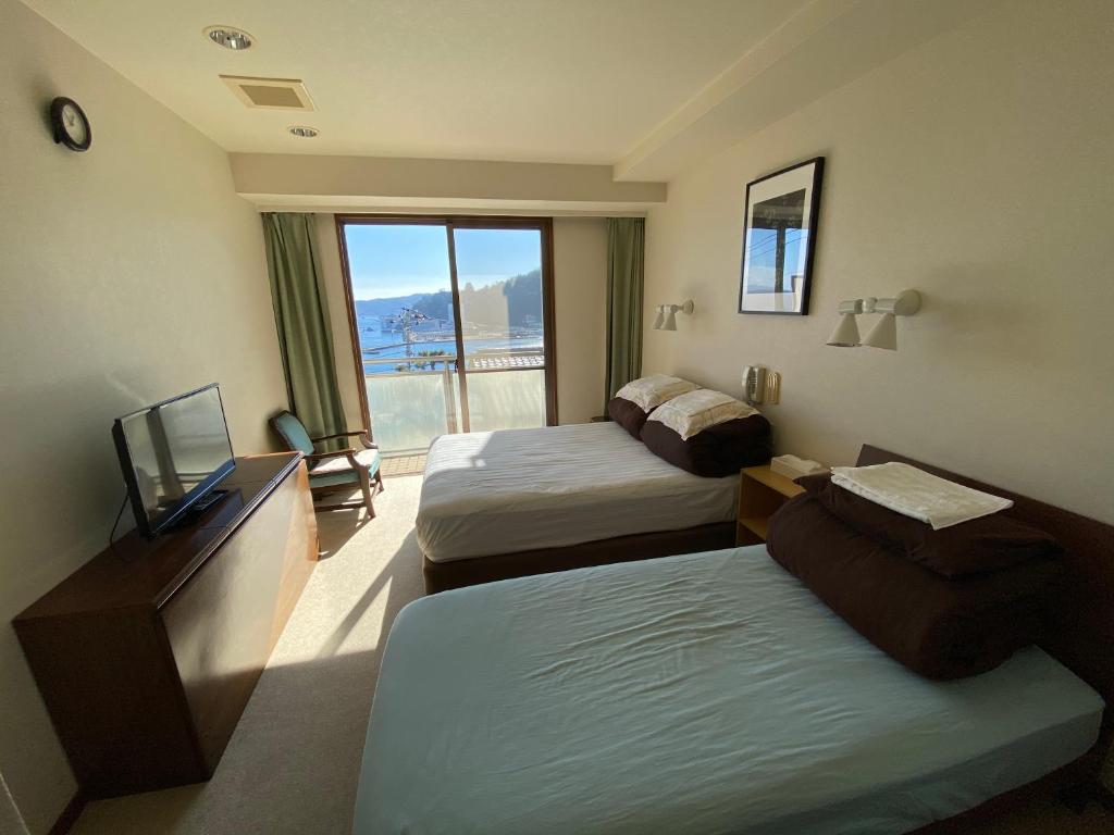 Postel nebo postele na pokoji v ubytování Atami Onsen Guest House Megumi
