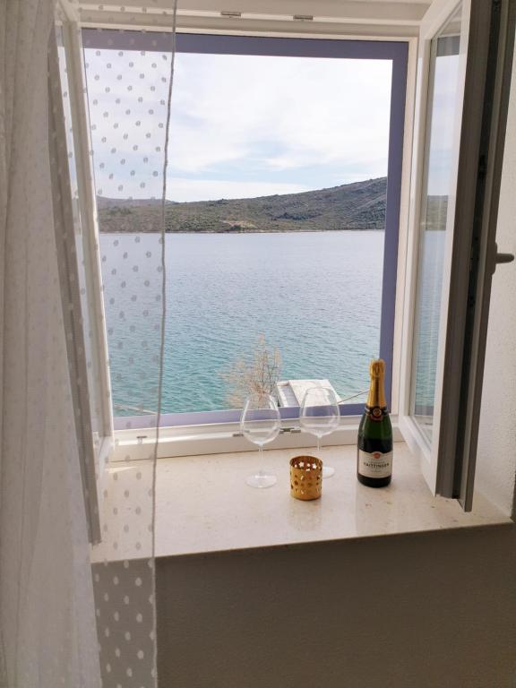 a window with two glasses and a bottle of wine at Rooms in Primošten
